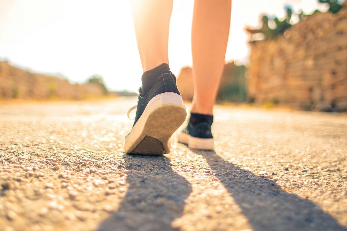 A picture of someone walking under the sun.