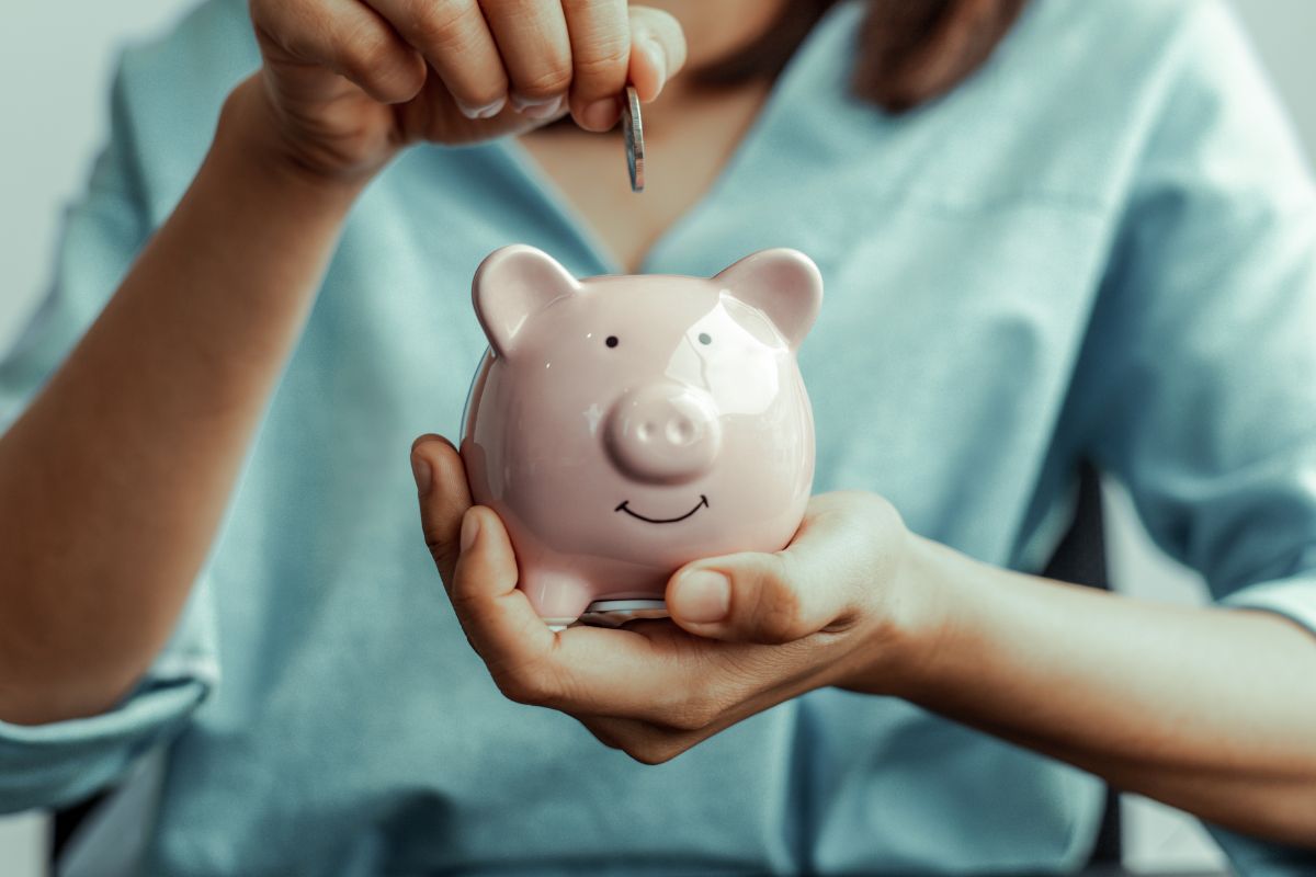 A picture of someone saving their money in a piggy bank. 