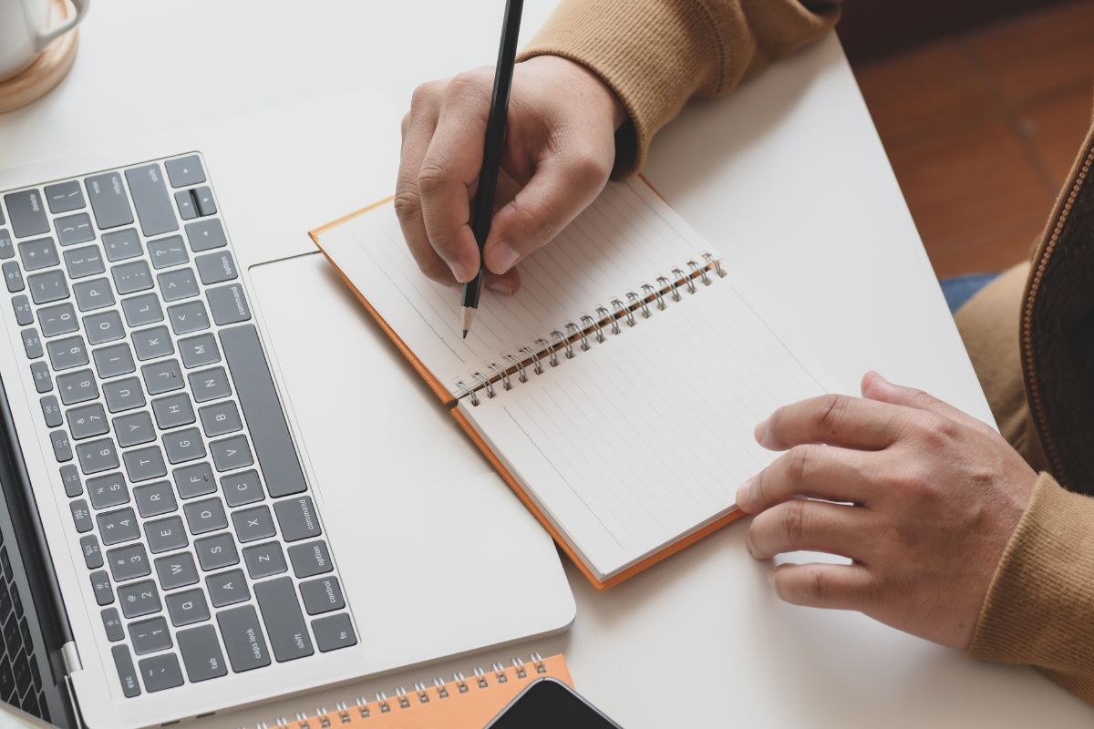 A picture of someone putting notes on a notebook. 