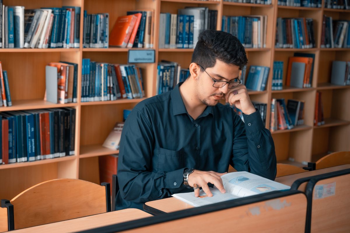 A picture of someone reading in a library. 