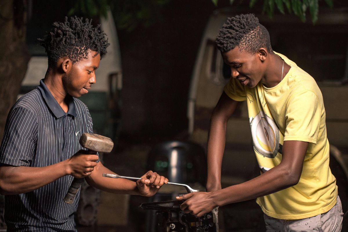 A picture of friends fixing something. 