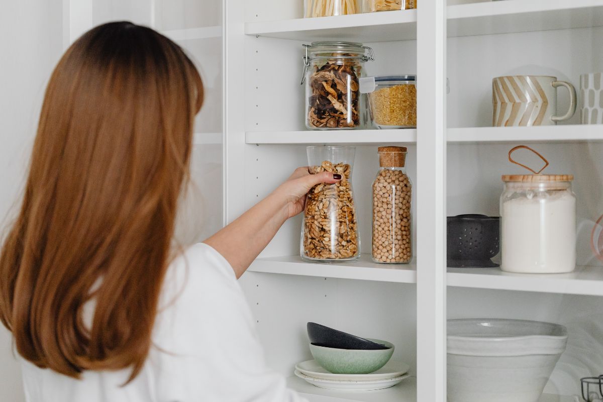 A picture of someone looking at their pantry. 
