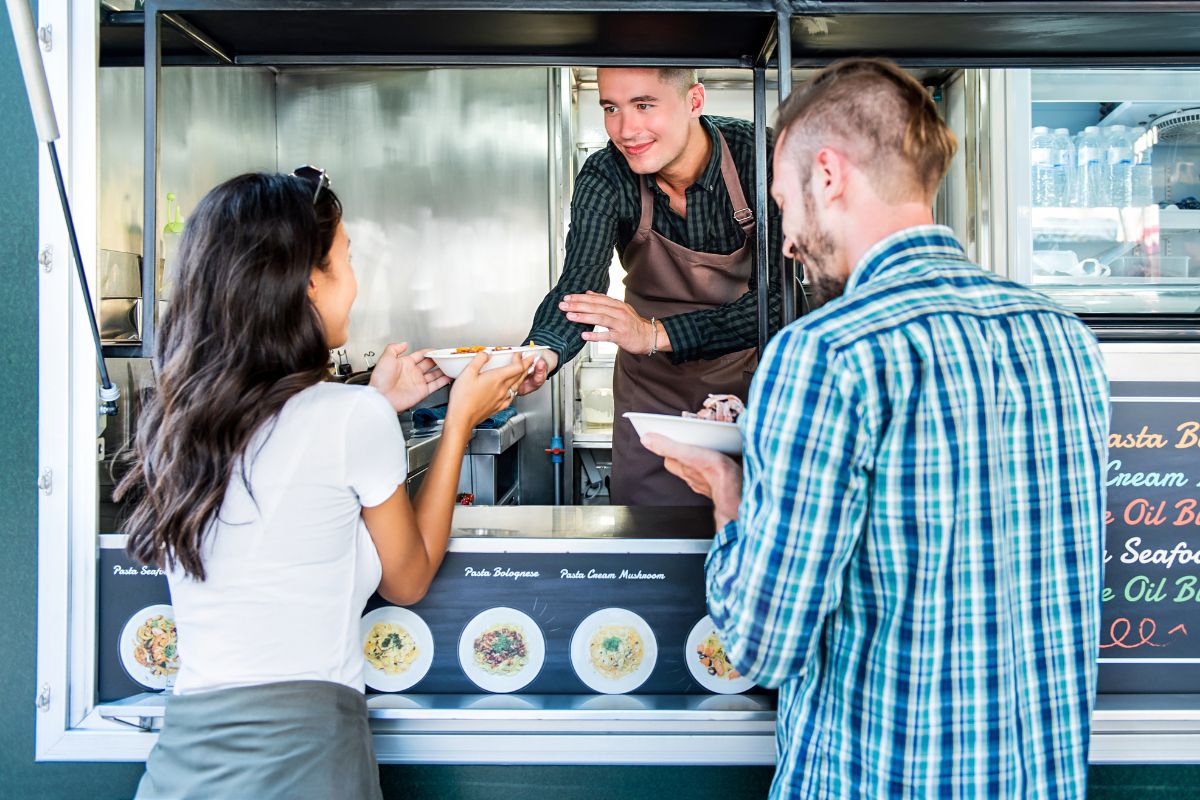 A picture of customers ioutside a food truck.