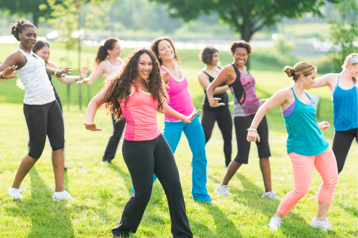 A picture of a fitness class in a park. 