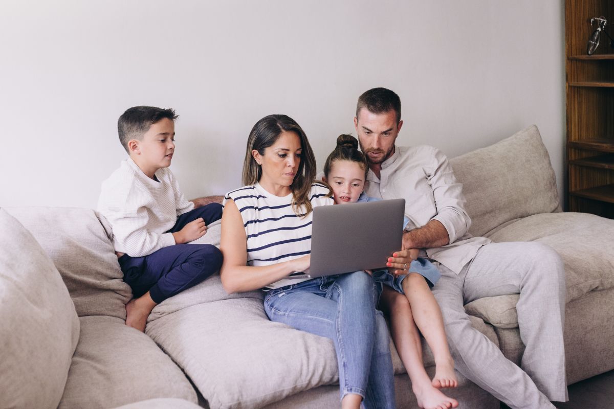 A picture of a family looking at their laptop.