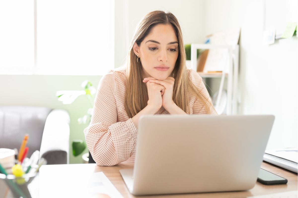 A picture of someone looking at their laptop.