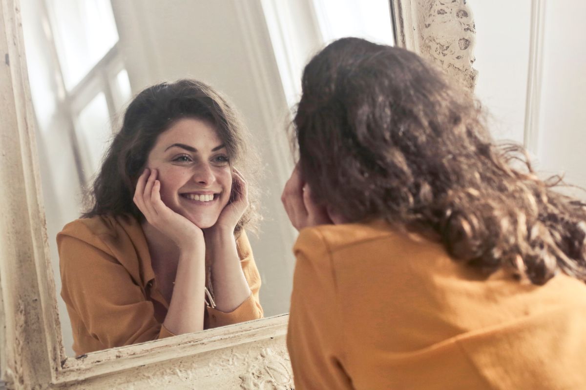 A picture of someone happily looking at themself in the mirror.