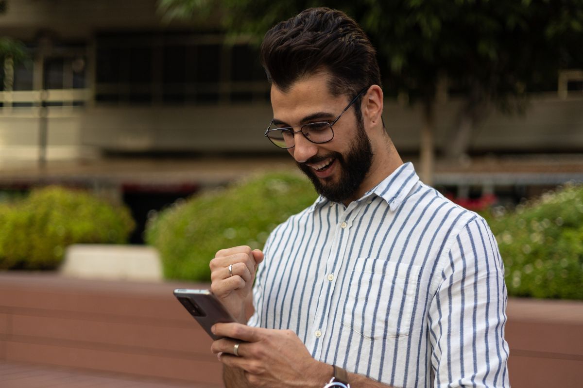 A picture of someone smiling while looking at their phone.