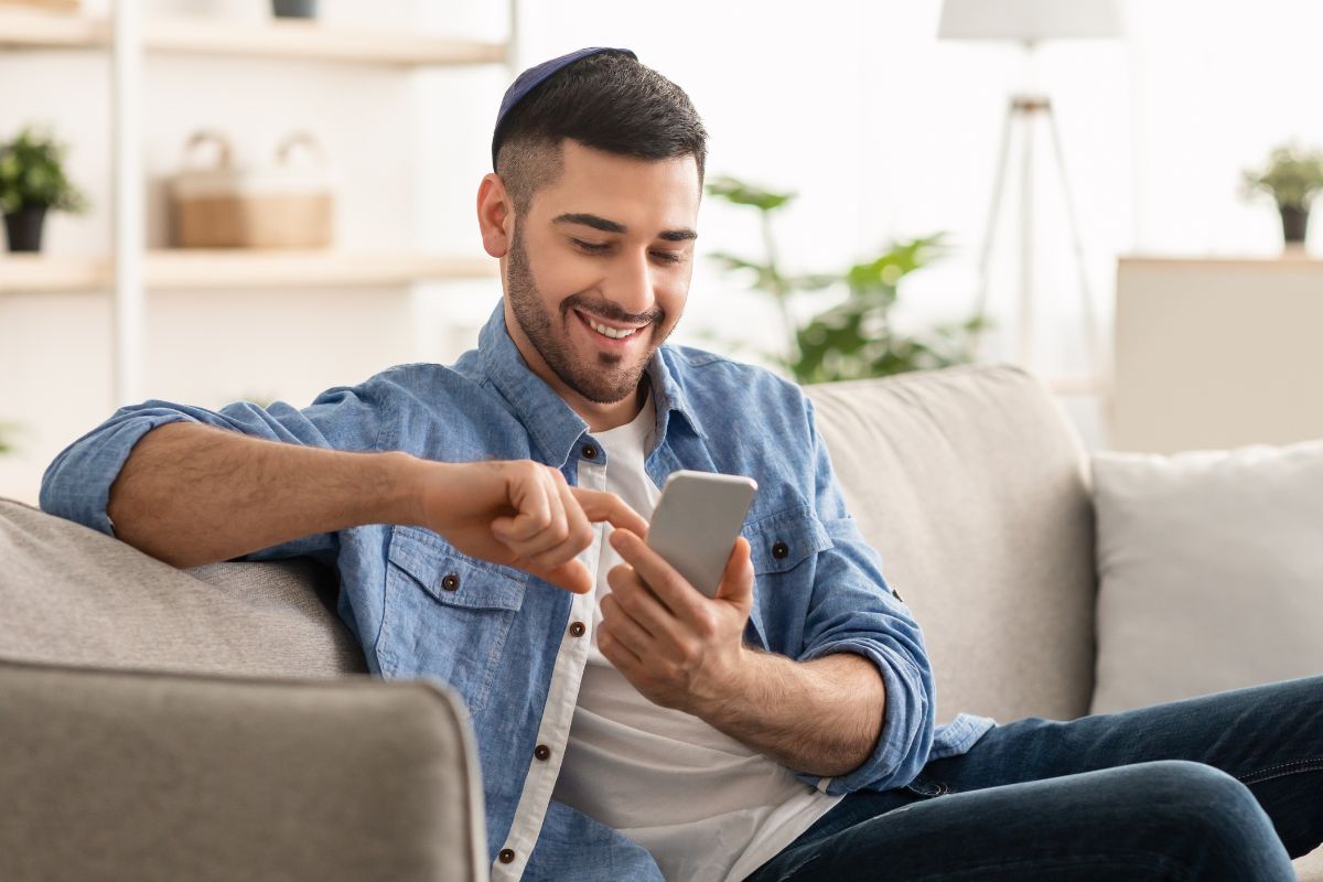 A picture of someone smiling while looking at their phone. 