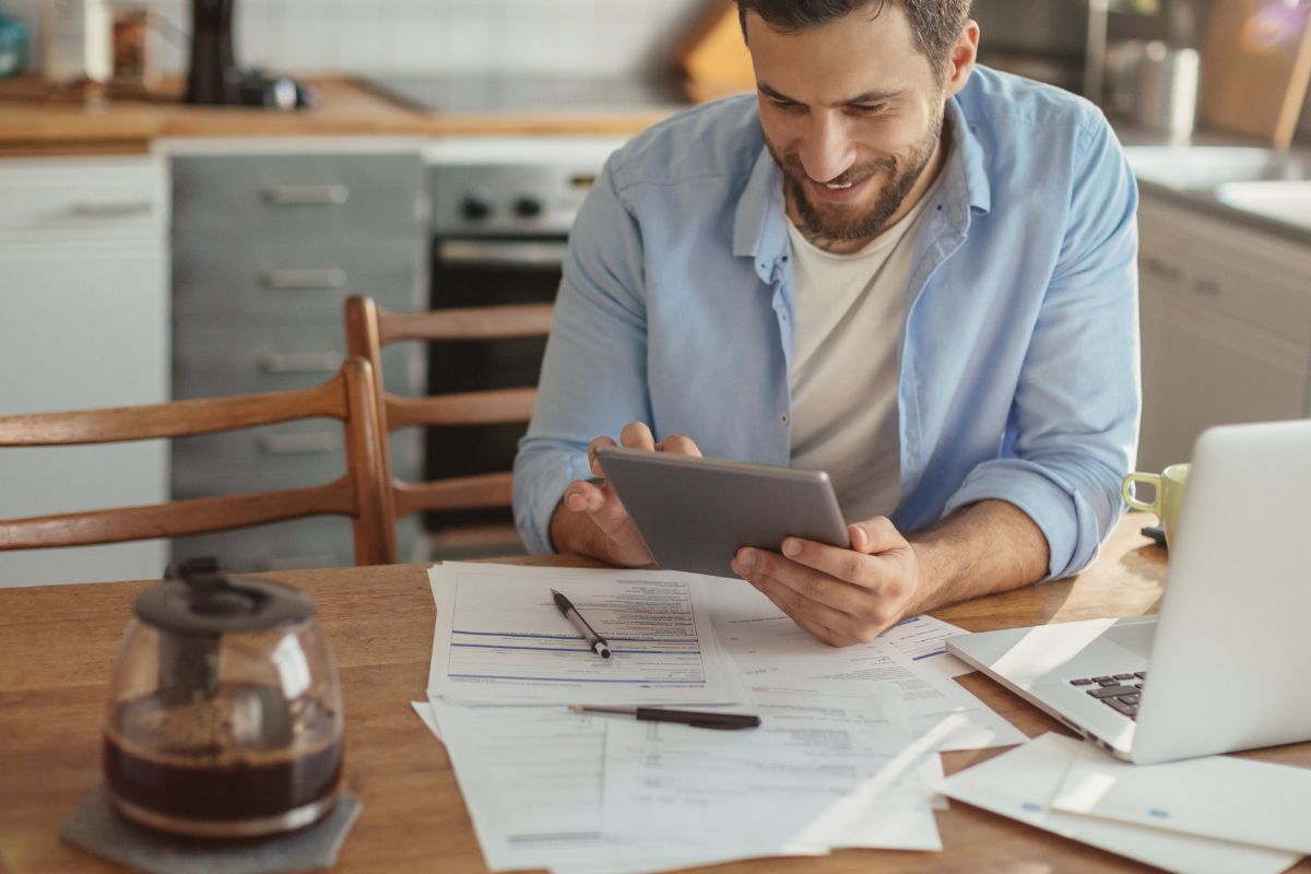 A picture of someone smiling while looking at their gadget. 