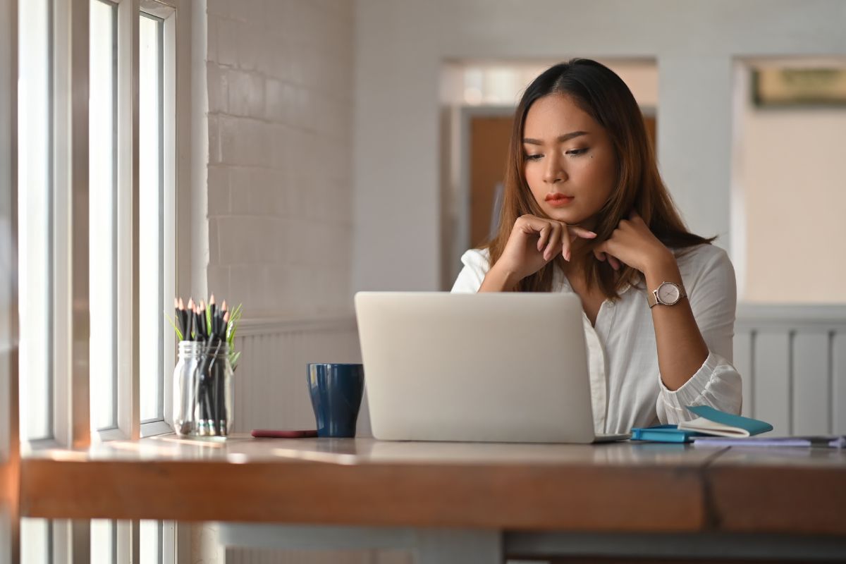 A picture of someone looking at her laptop. 