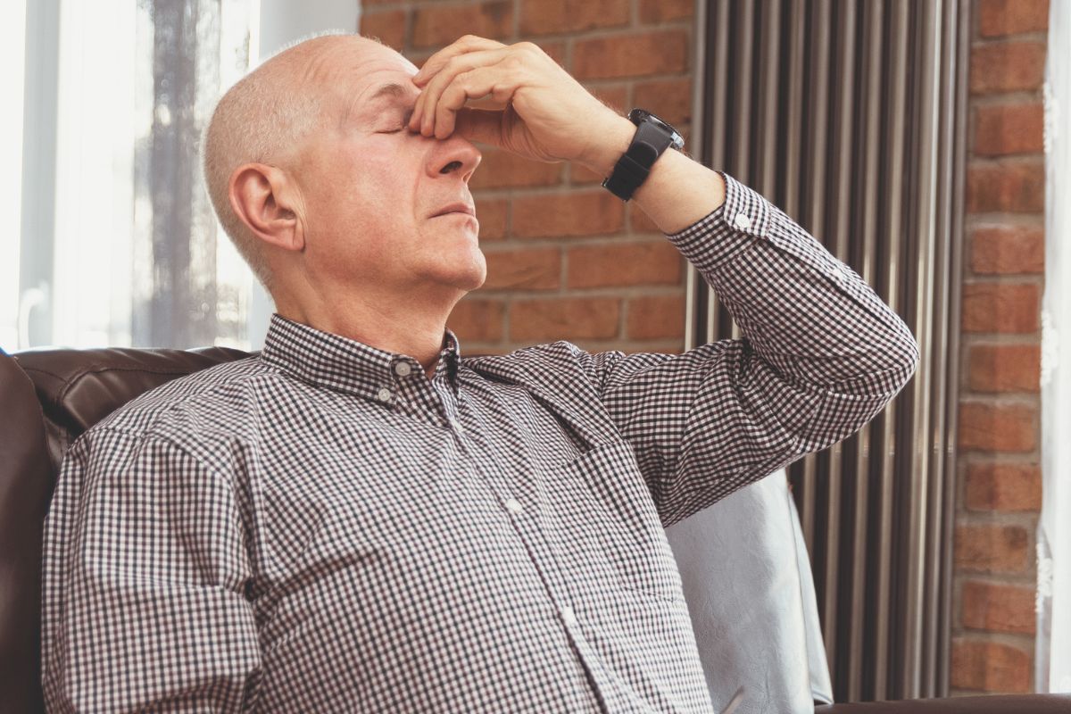 A picture of an old person with a headache. 
