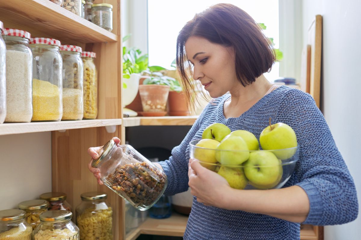 A picture of someone looking at her pantry. 