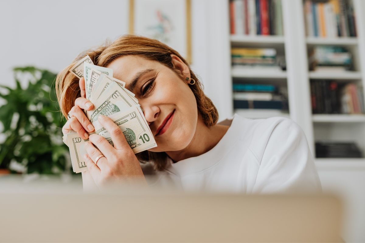 A picture of someone smiling with money. 