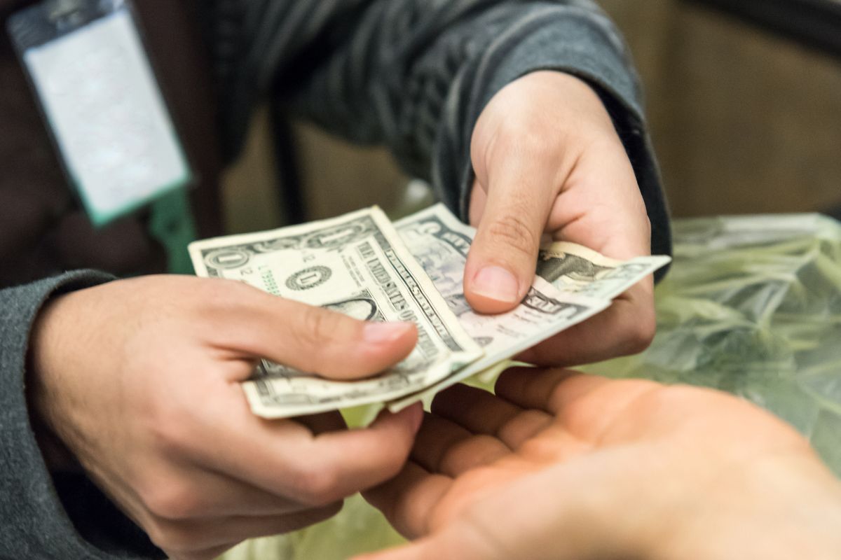 A picture of someone giving $3. 