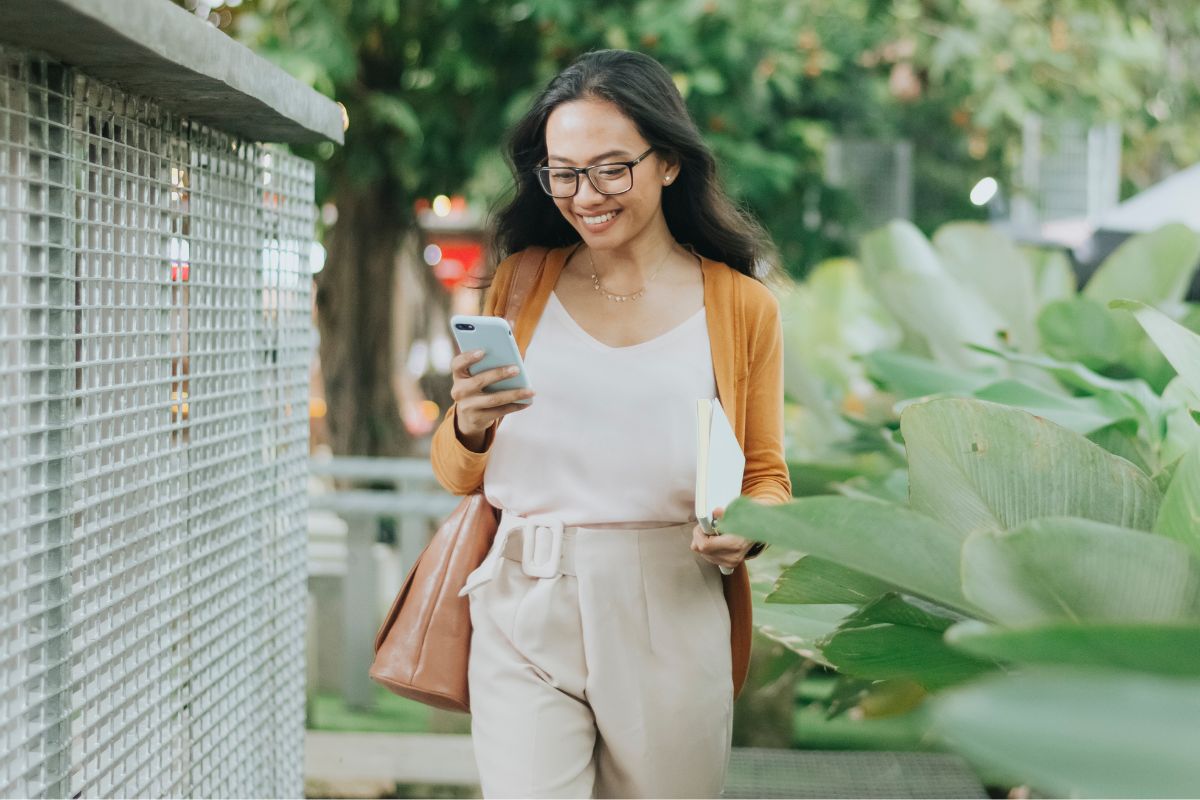 A picture of someone smiling while on the phone. 