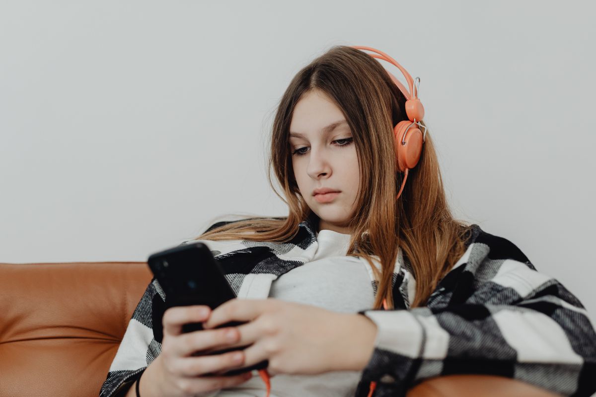 A picture of a teen using their phone. 