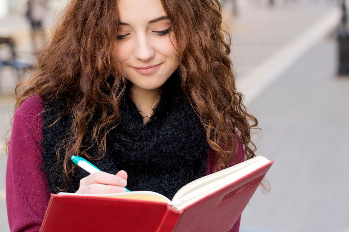 A picture of a woman writing something down. 