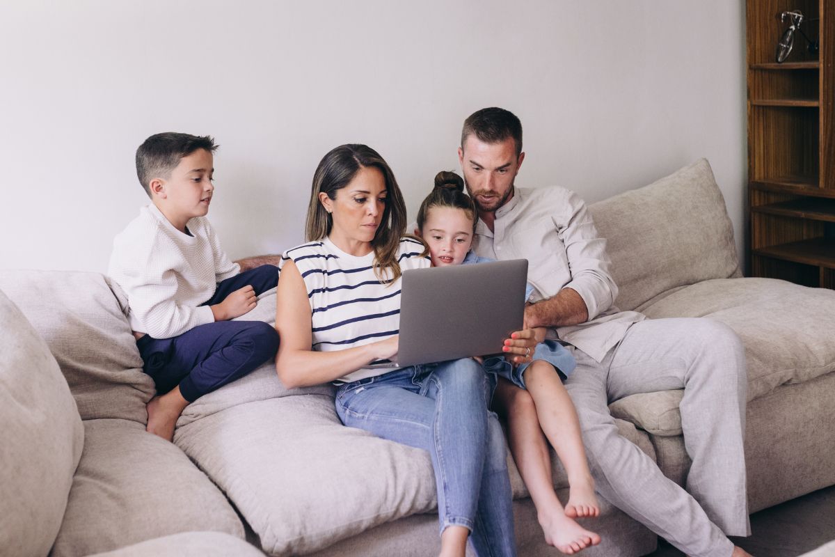 A picture of a family looking at a laptop. 