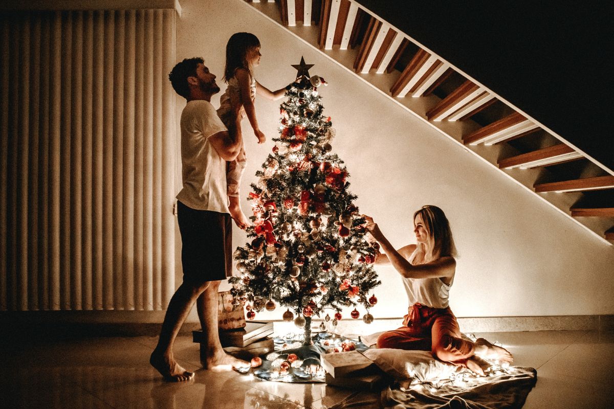 A picture of a family putting up a Christmas tree. 