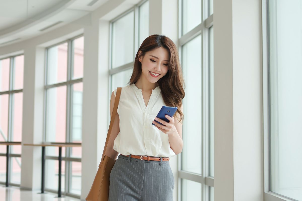 A picture of someone smiling while looking at their phone.