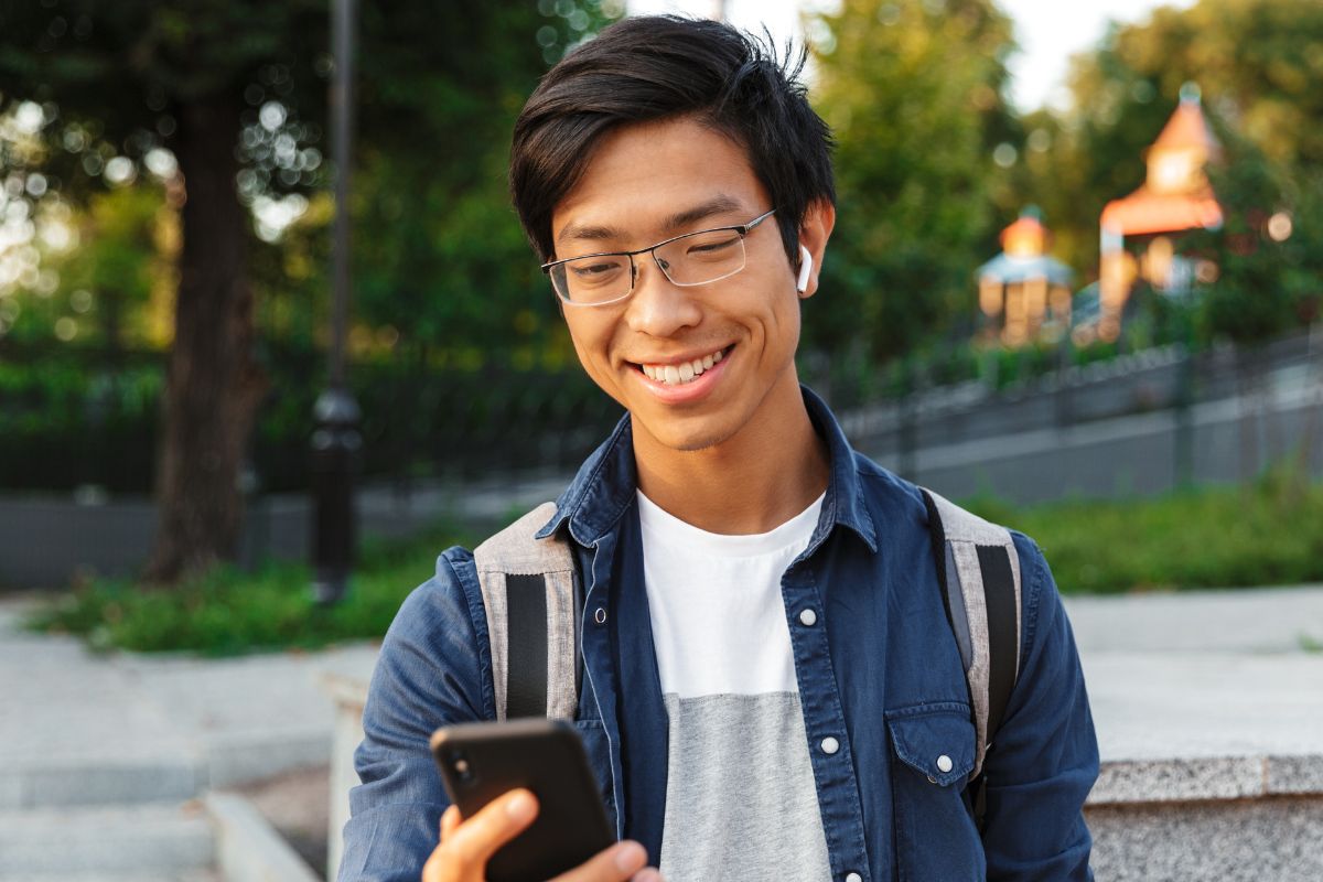 A picture of someone smiling while using their phone.