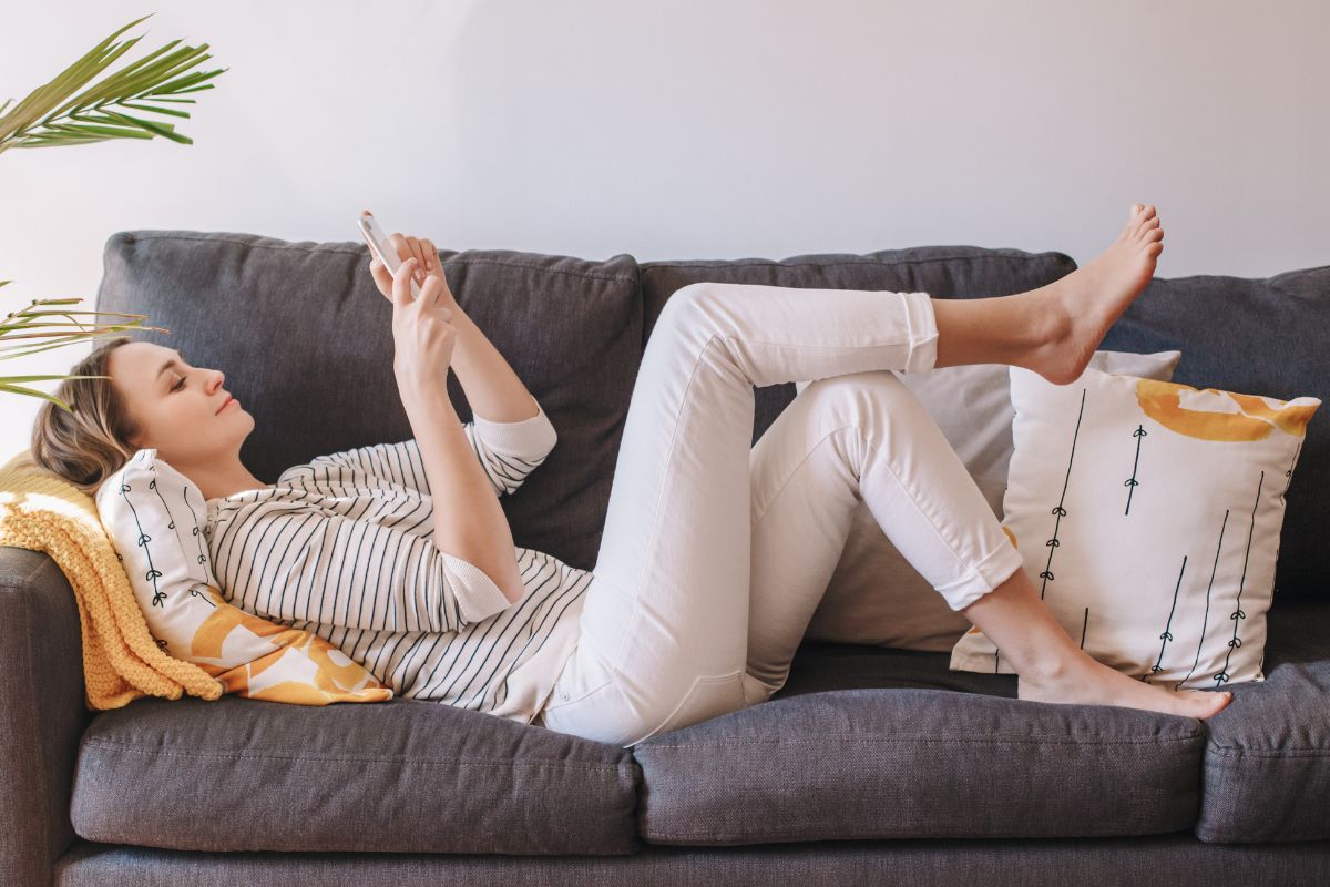 A picture of a person relaxing on their sofa.