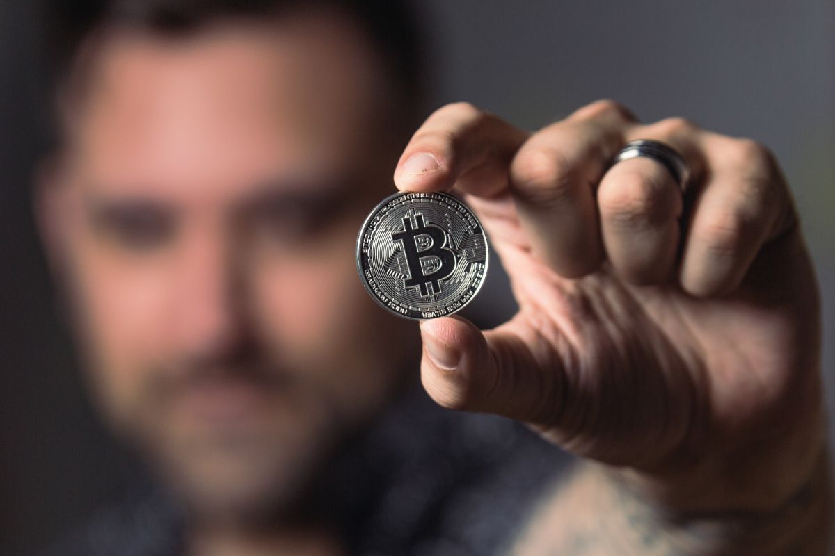 A picture of someone holding a bitcoin coin.