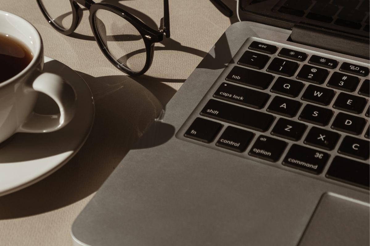 A picture of a laptop, coffee, and glasses.