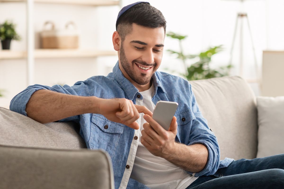 A picture of someone smiling while using their phone.