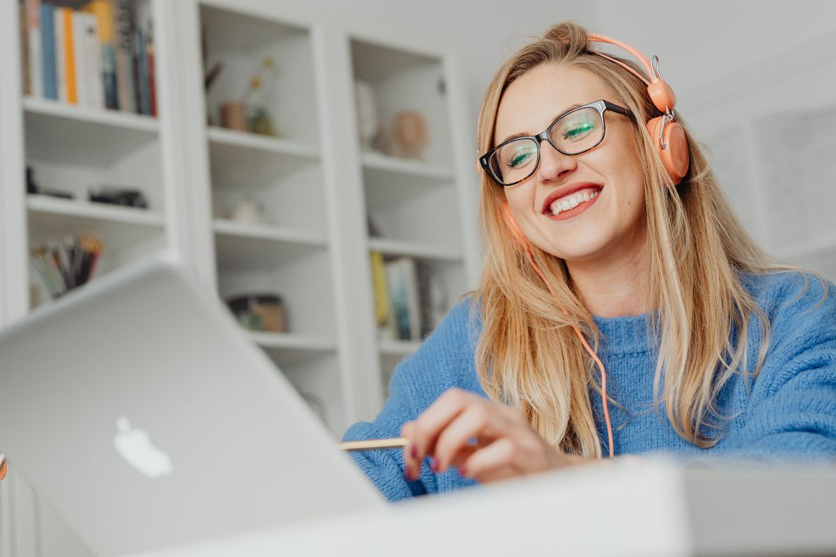 A picture of someone smiling while using their laptop.