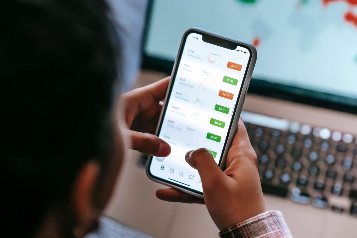 A picture of someone trading using their phone.