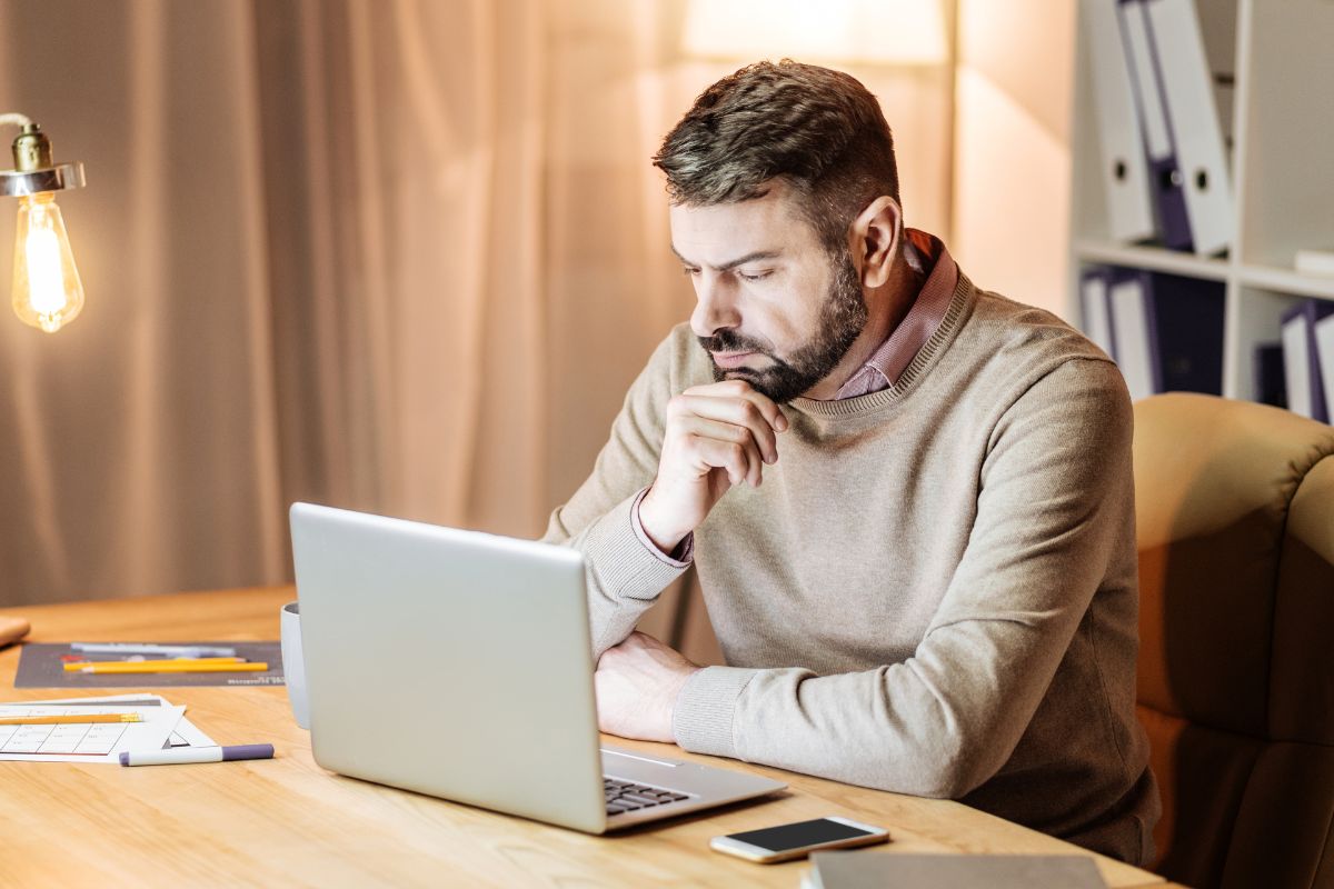 A picture of someone looking at their laptop.
