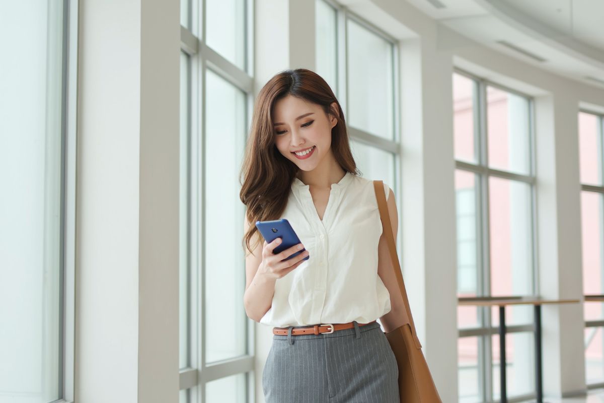 A picture of someone smiling while using their phone.