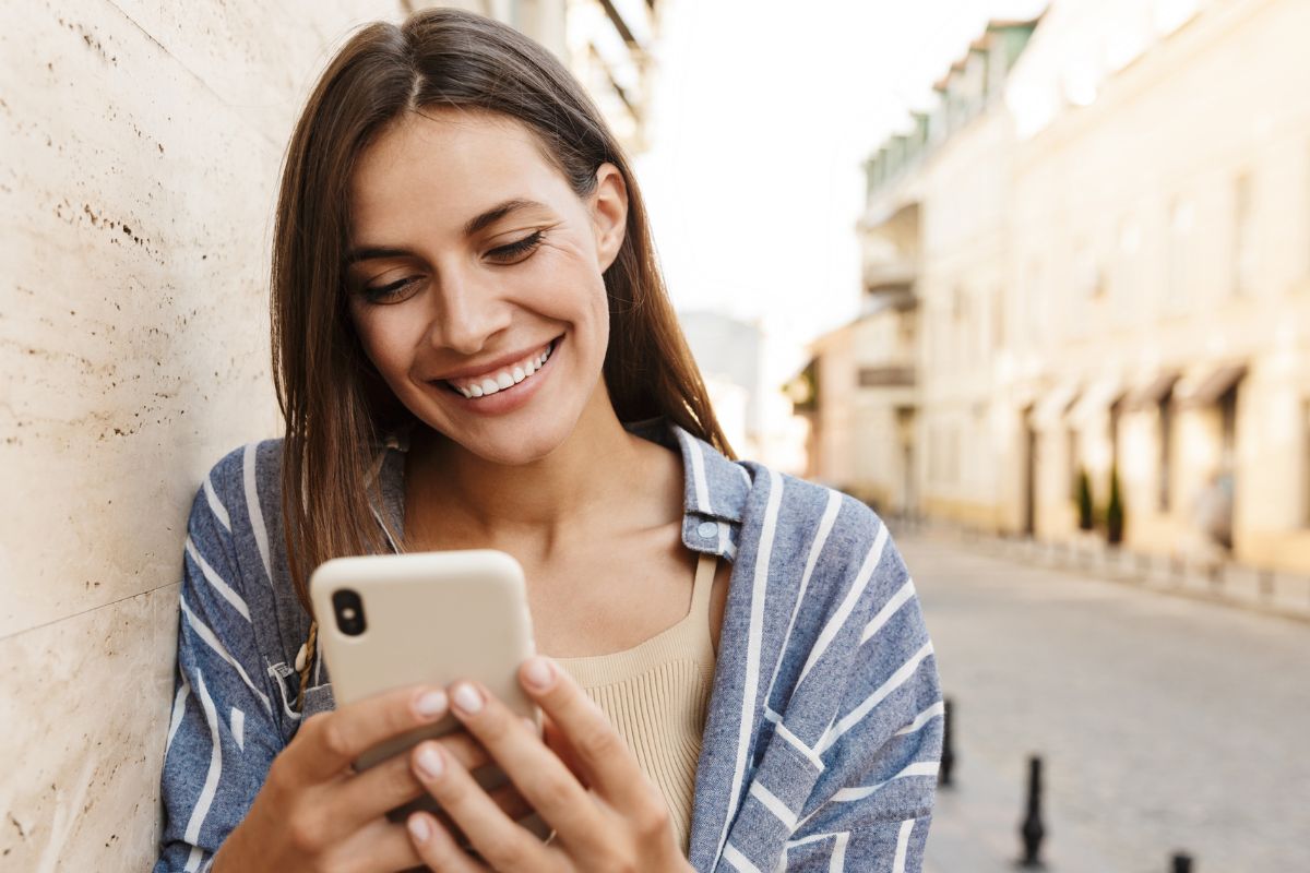 A picture of someone smiling while using their phone.