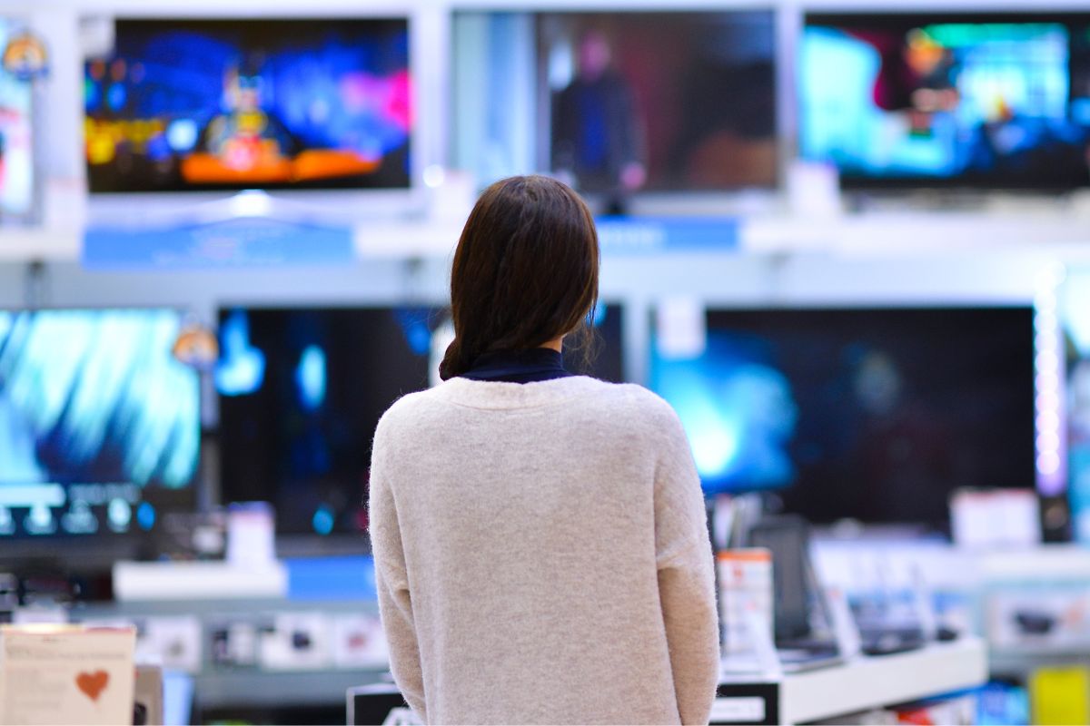 A picture of someone shopping for TVs.
