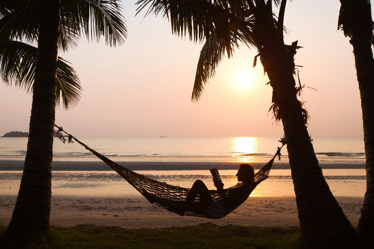 A picture of someone reading in a hammock.