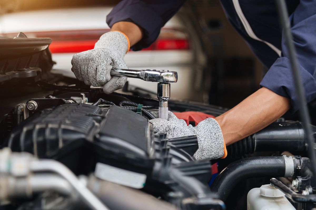 A picture of someone repairing a car.