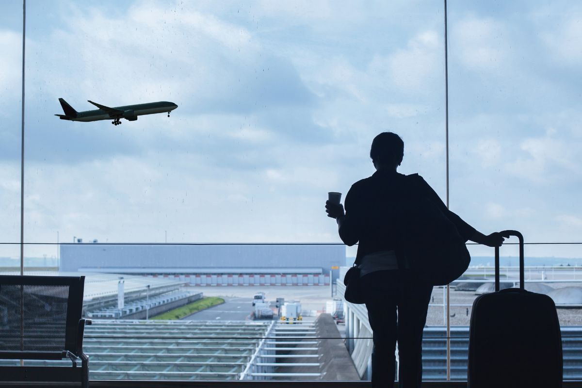 A picture of a traveler looking at an airplane.