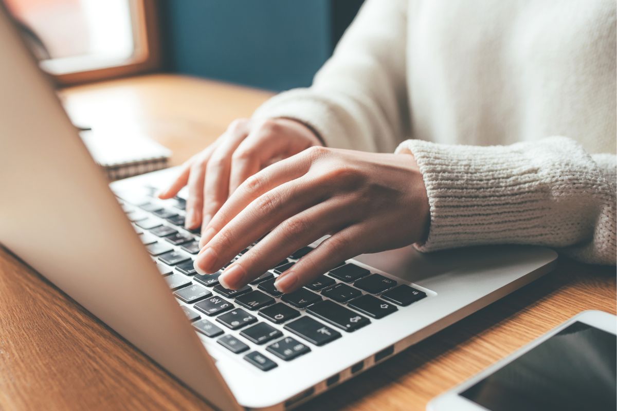 Picture of a woman's hand using a laptop.
