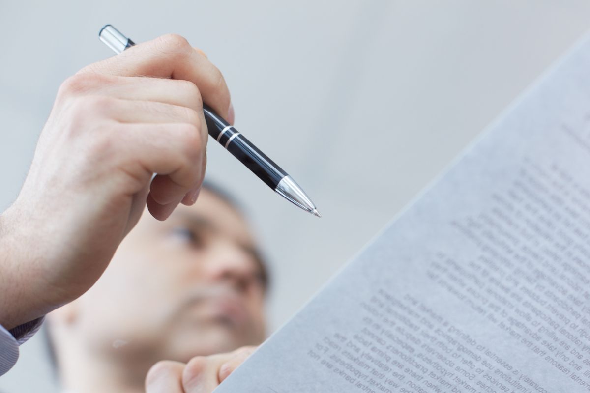 A picture of someone holding a pen and a paper.