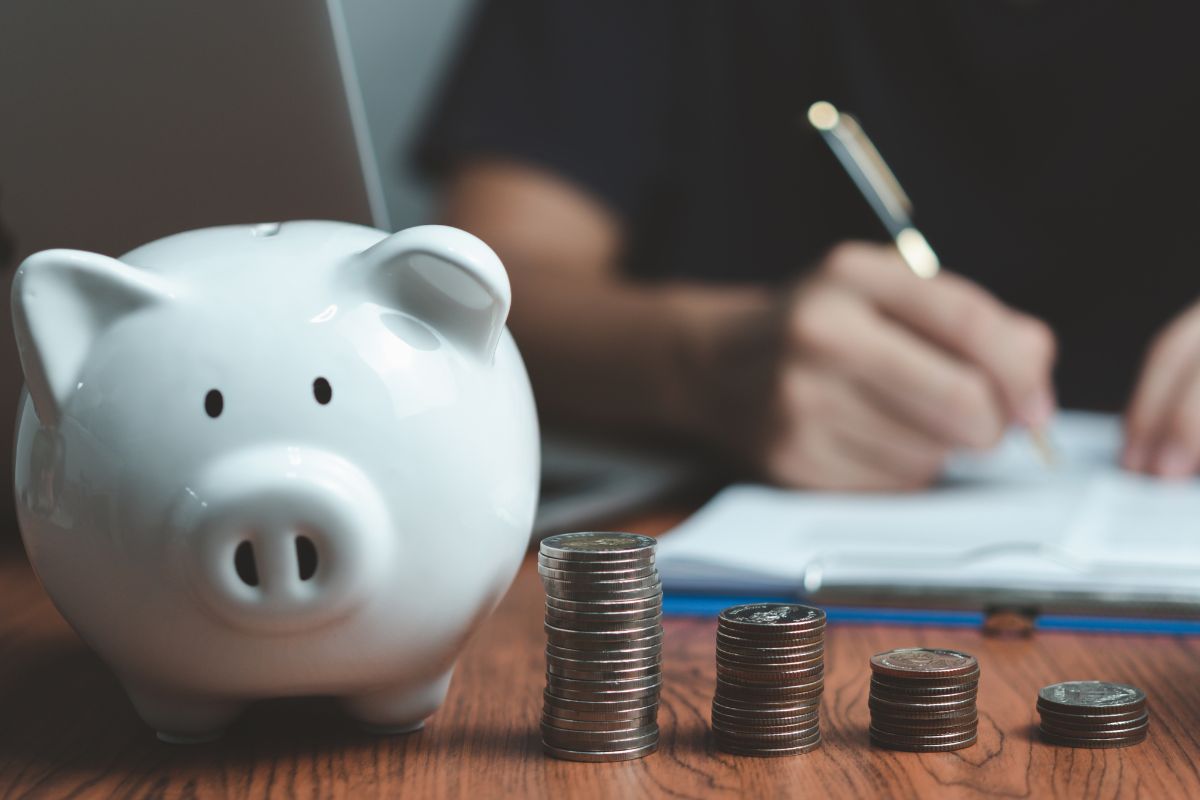 A picture of a piggy bank with coins on its side.