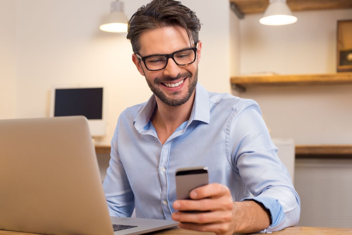 A picture of someone smiling while using their phone.