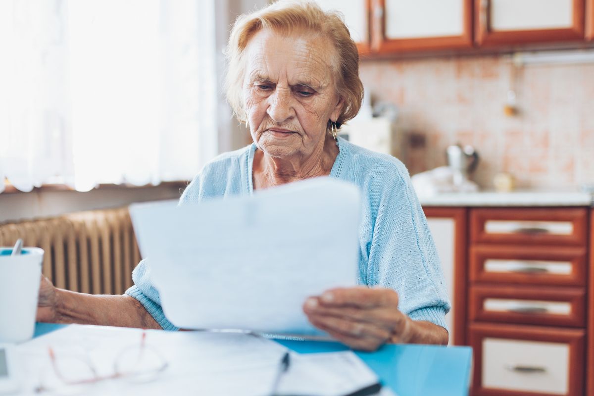 A picture of an elderly woman reviewing her finances.