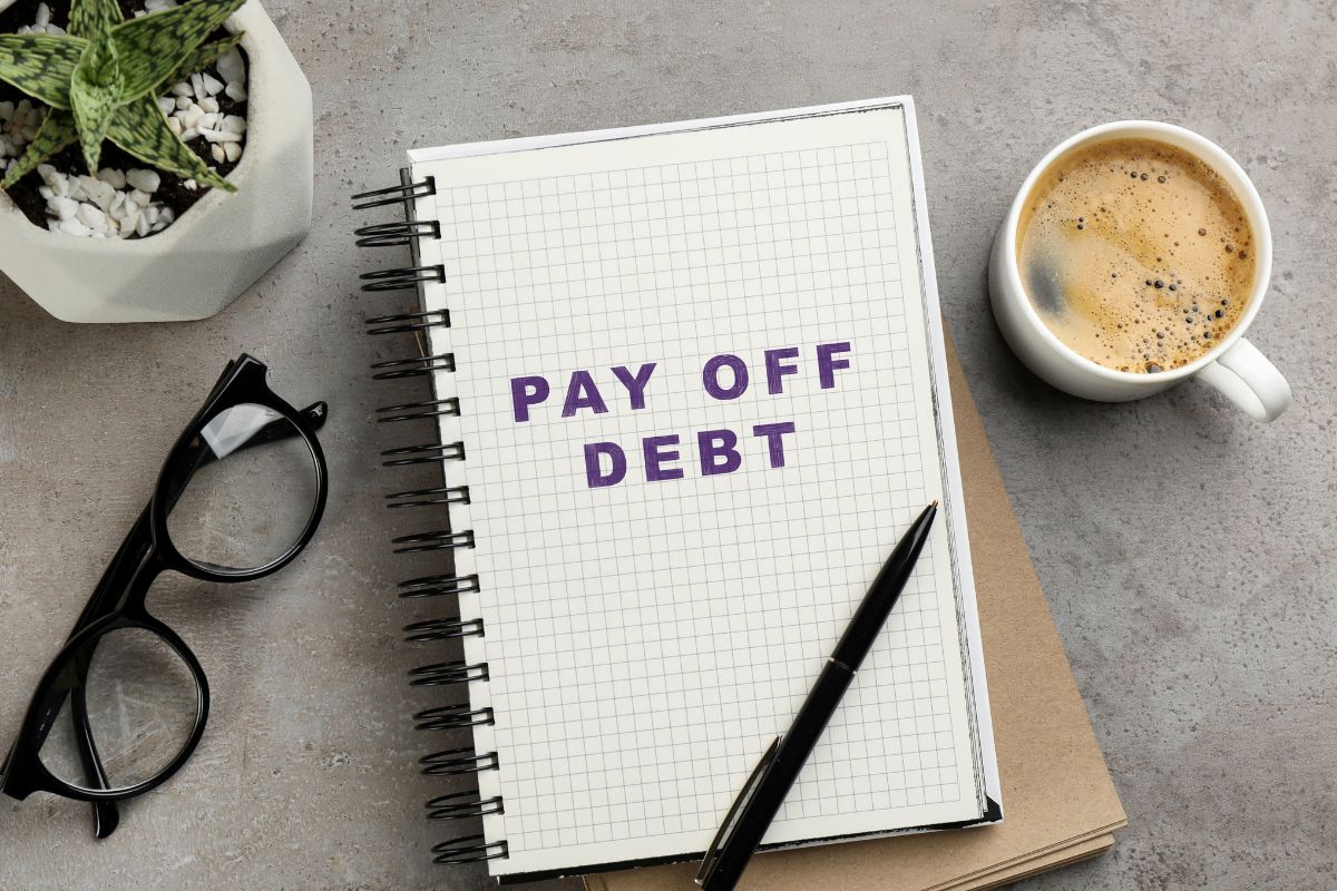 A picture of a notebook with the words "PAY OFF DEBT".