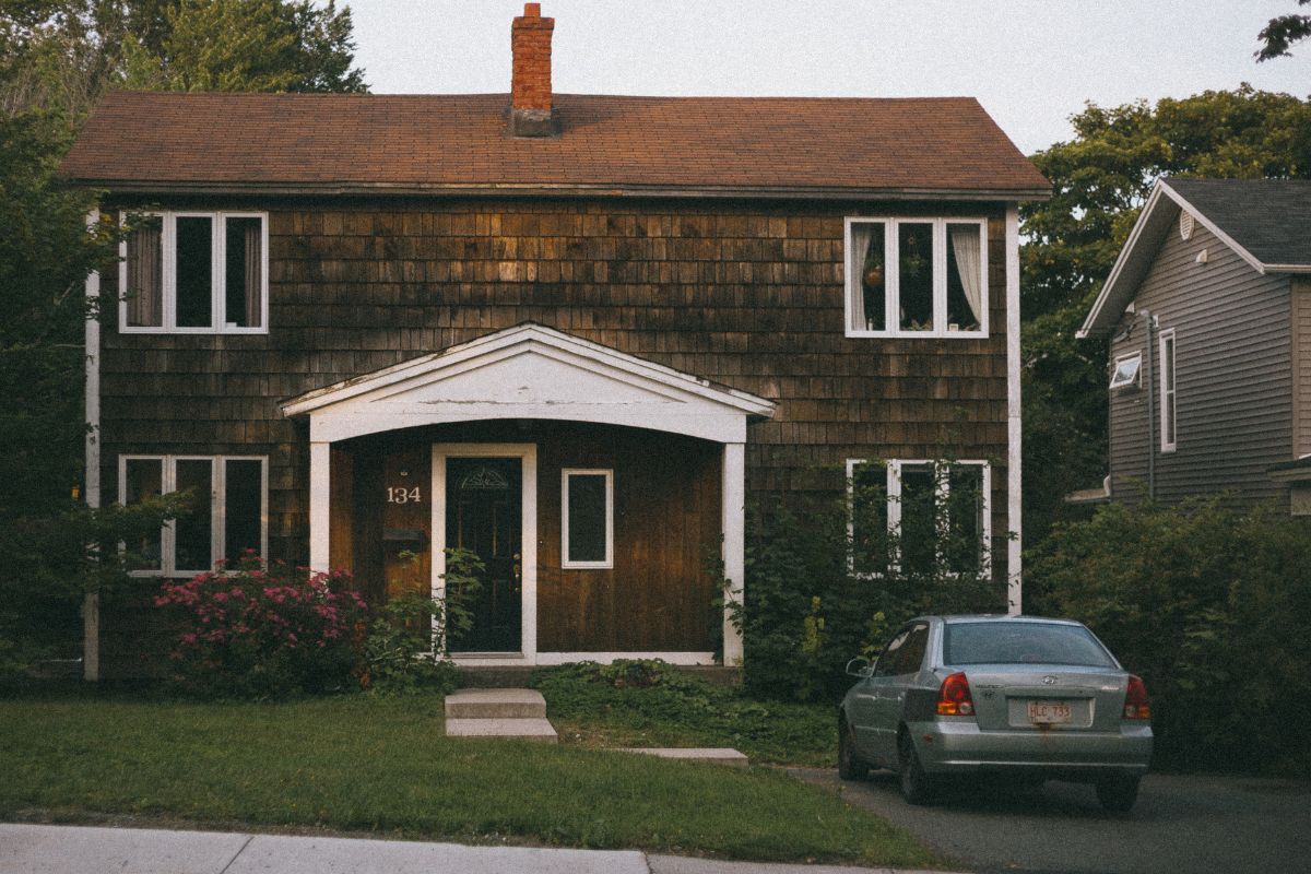 A picture of a house with a car in its driveway.