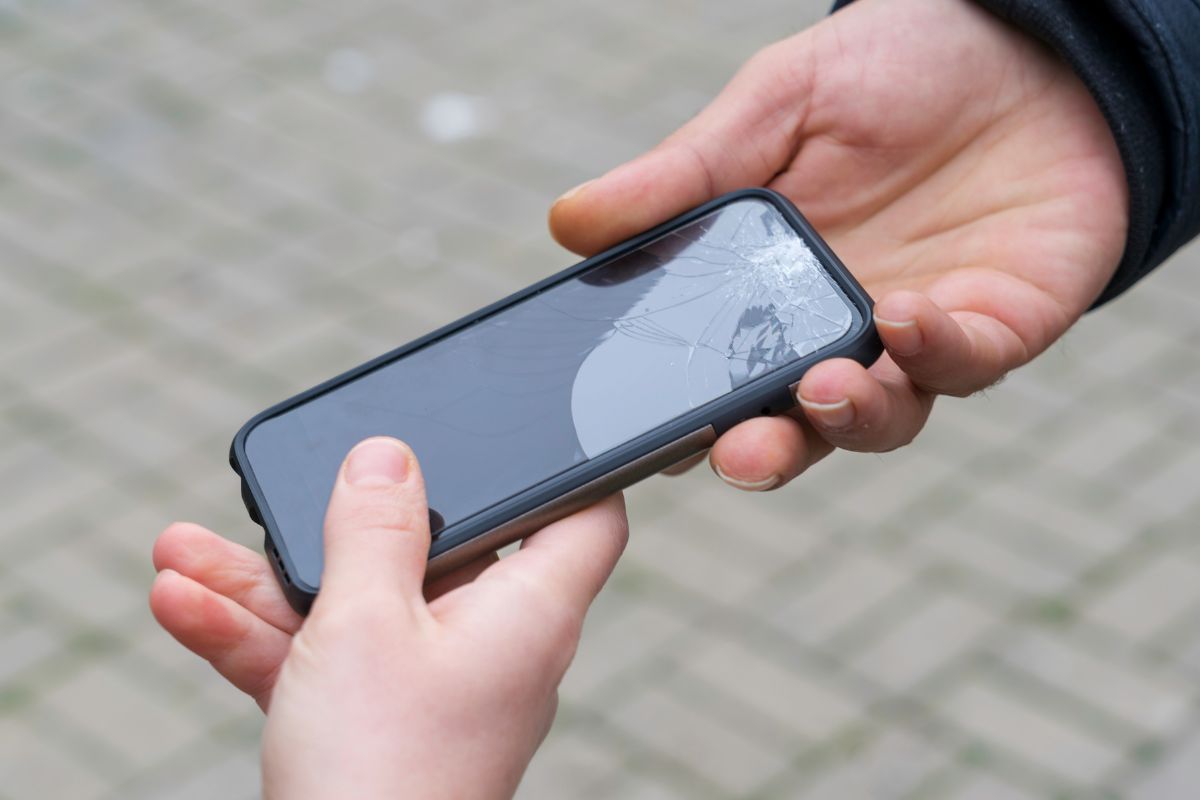 A picture of someone giving a broken smartphone.