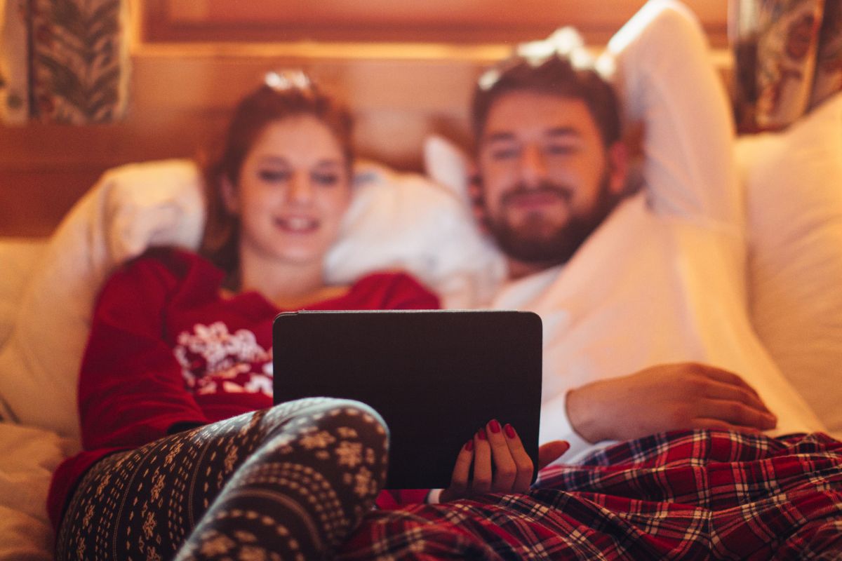 A picture of a couple watching something.