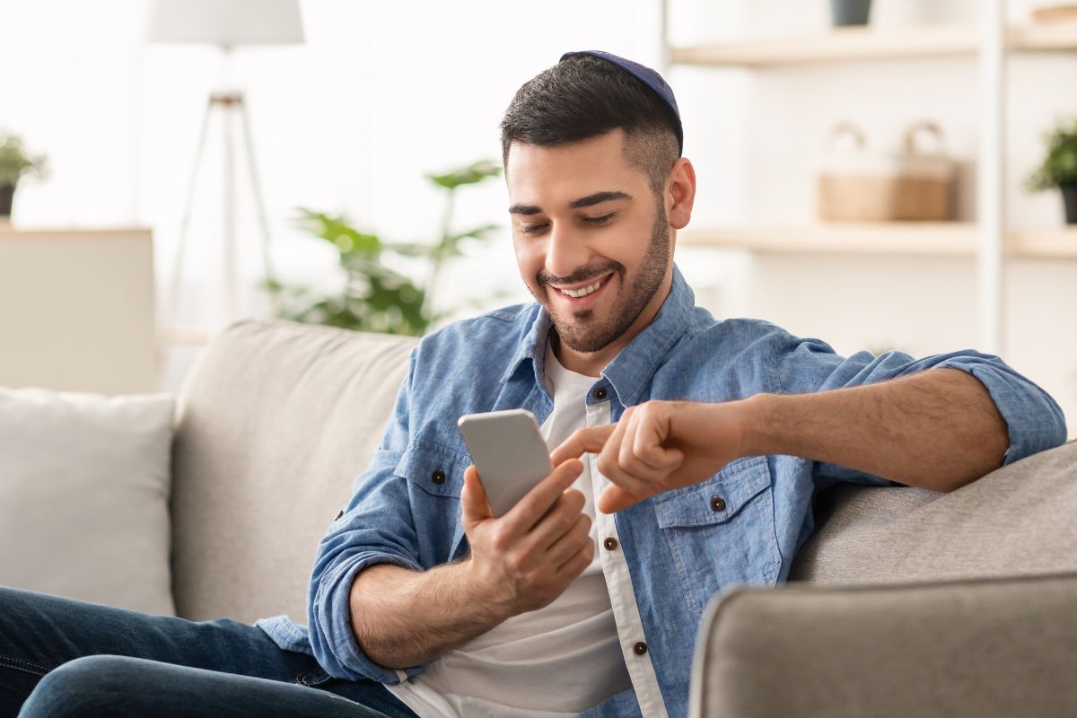 Uma foto de um homem usando seu smartphone. 