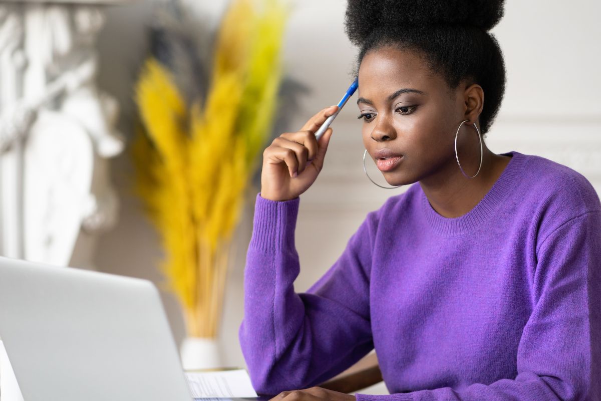 A foto de uma mulher olhando para seu laptop. 